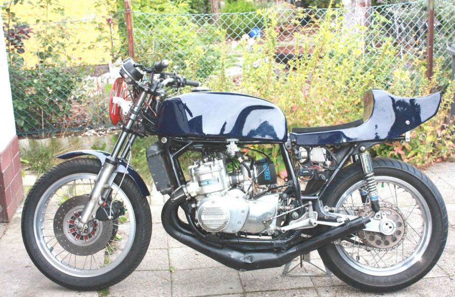 Reimo Suzuki GT-R 750
GT 750 J, `72, modifiziert, ca. 85-90 PS.
Rahmen verstärkt, Gabel luftunterstützt, L-Dämpfer, JMC Alu Kastenschwinge, Hagon Dämpfer,
Reimo Tank und Bank, sowie Motortuning; Vergaser Mikuni VM 36, Kupplungskorb verstärkt (Reimo), Barnett Kevlar- Kupplungsbeläge,Tarozzi Auspuffanlage und Fussrasten, Lenker ABM, GS 1000 Bremssättel, Bandit Bremszylinder, Spiegler Stahlflex, gelochte Serienscheiben, Accent Zündung.
