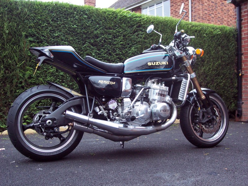 Suzuki GT750
Stan Stephens gave the barrels and ports some tuning and a TR spec crank keeps it all together ! Allspeed expansion chambers have just been replaced along with a set of larger 36mm carbs. Paint follows B model styling but has a deep blue metalflake in it so it really gistens in the sun . I am pleased with it so far4 , knocking out about 79bhp. Raced a track days and ridden in all weathers - it never lets me down.............building another 3 for next season and a crazy track GT750 racer... 
Schlüsselwörter: Suzuki GT750 - K5 Kettle