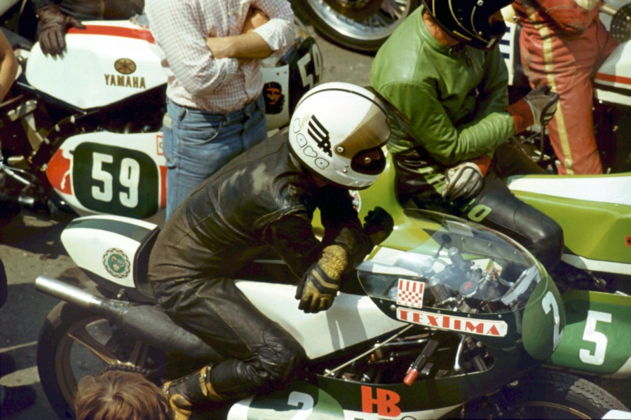 Frank Wendler am Vorstart 250 ccm Sachsenring 1980
1979 besorgte der MC Hohenstein-Ernstthal für Frank Wendler  eine ehemalige 250er Werks-MZ. Frank verbesserte das Fahrgestell und Hartmut Bischoff überarbeitete den Zweizylindermotor. Ab 1980 startete Frank nur noch in der Viertelliterklasse und holte mit dieser Maschine die DDR-Meisterschaft 1980 und 1981.
Schlüsselwörter: Peter Wolf